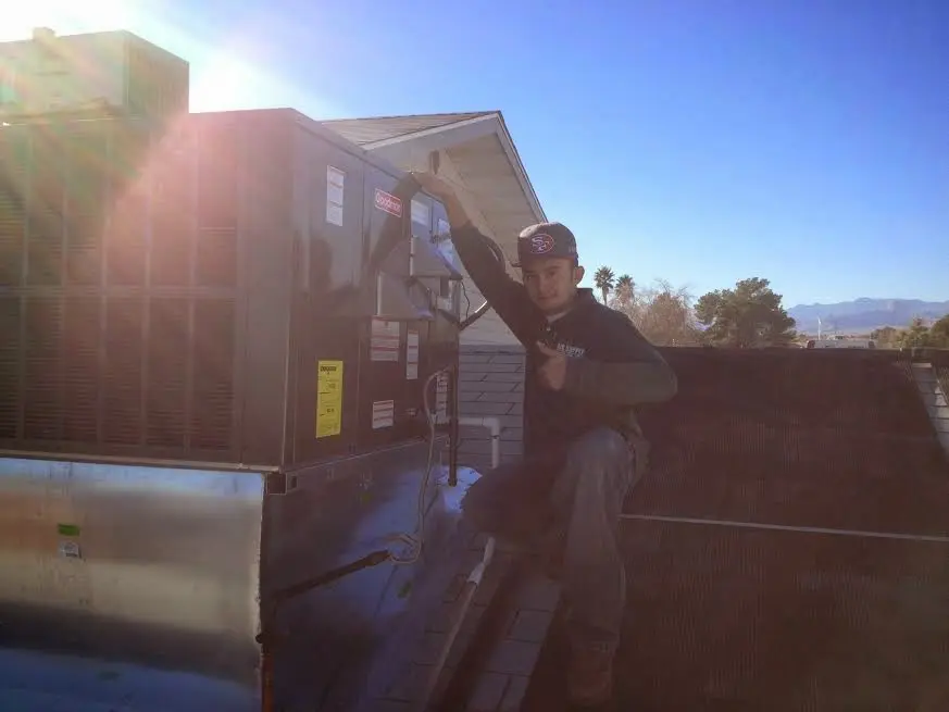 HVAC technician performing Air Duct Cleaning on a rooftop unit in Sevierville